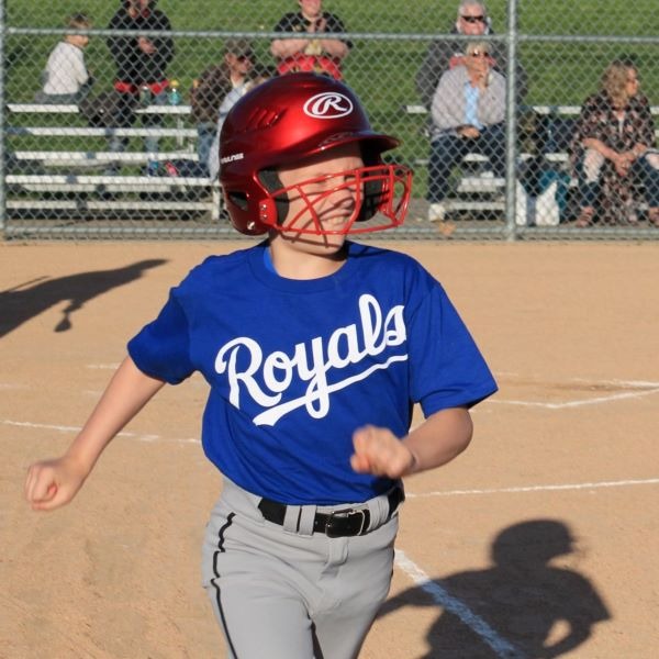 Boy running the bases at baseball game.