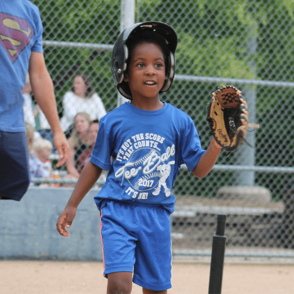 Little holding up his glove at Tee-Ball game.